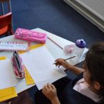 girl writing onto paper