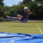 girl jumping over a pole