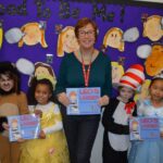 Teacher and students holding Leo's ladder book